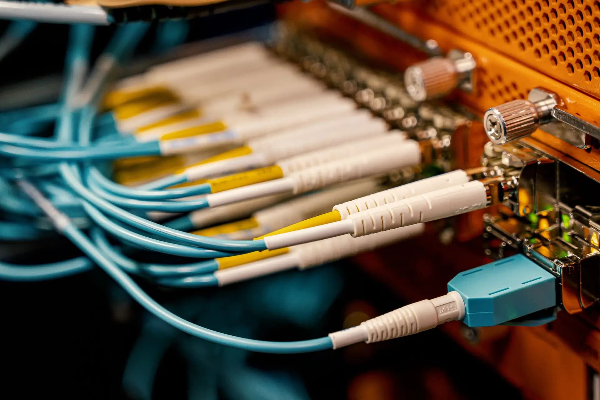 Fibre optic patch cables plugged into the SFP ports of an access switch.